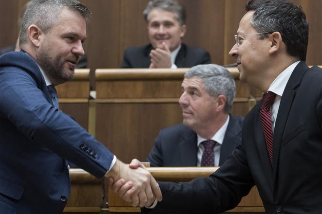PM Peter Pellegrini and Finance Minister Laislav Kamenický shake hands after parliament passed the state budget for 2020.  