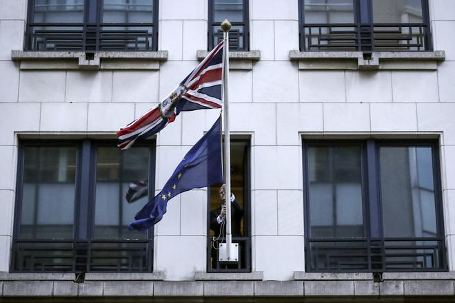 A member of protocol removes the EU flag from the UK Permanent Representation to the EU in Brussels on January 31, 2020. 