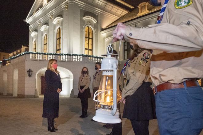 Slovak President Zuzana Čaputová accepts the Peace Light of Bethlehem from scouts at the Presidential Palace on December 15, 2020. The tradition, launched in Austria in 1987, has spread to many European countries and the Americas since then.