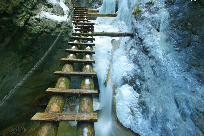 Climbing ladders in the Slovak Paradise National Park during winter.
