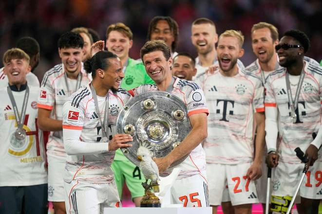 Thomasom Müller (uprostred) sa teší zo zisku bundesligového titulu so spoluhráčmi.