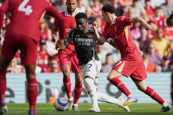 Bukayo Saka (Arsenal) v obklopení hráčov Liverpoolu.