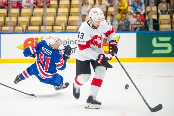 Americký hráč Frank Nazar (vľavo) bojuje o puk so Švajčiarom Andreom Glauserom v zápase B-skupiny USA - Švajčiarsko.