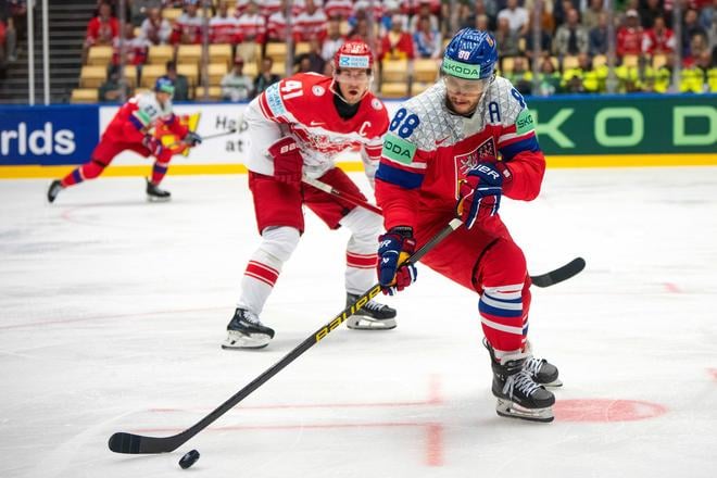 Český hráč David Pastrňák (vpravo) uniká s pukom pred Dánom Jesperom Jensenom Aabom v zápase B-skupiny Česko - Dánsko.