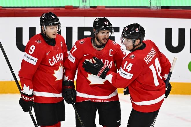 Kanadský hráč Sidney Crosby (uprostred) oslavuje so spoluhráčmi Nateom MacKinnonom (vľavo) a Bo Horvatom po tom, ako skóroval v zápase A-skupiny Kanada - Francúzsko na MS 2025 v hokeji.