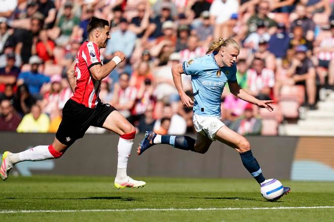Na snímke hráč Manchesteru Erling Haaland (vpravo) a hráč Southamptonu Jan Bednarek bojujú o loptu v zápase 36. kola anglickej Premier League.