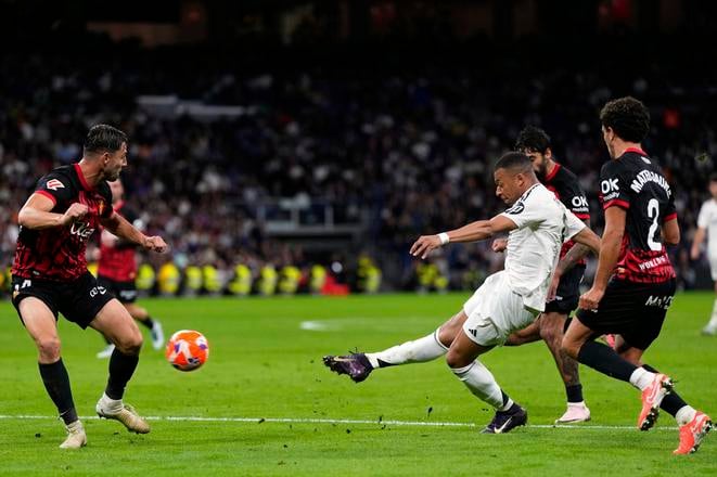 Slovak defender Martin Valjent (left) of RCD Mallorca watches as Real Madrid’s Kylian Mbappé (second from right) fires a shot on goal during the La Liga match between Real Madrid and Mallorca in Madrid on Wednesday, 14 May 2025.
