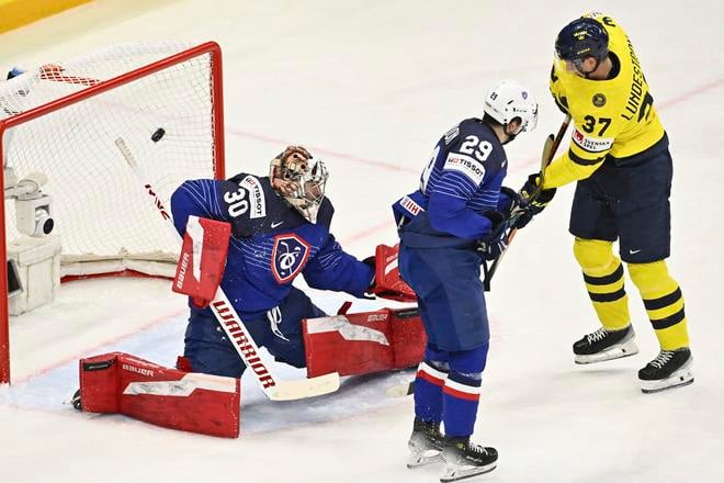 Švédsky hráč Lucas Raymond (vpravo) strieľa gól brankárovi Antoinemu Kellerovi z Francúzska v zápase A-skupiny Francúzsko - Švédsko na MS v ľadovom hokeji v Štokholme.