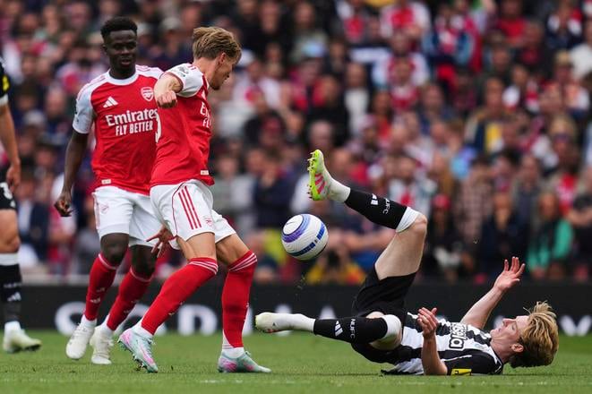 Hráč Arsenalu Londýn Martin Odegaard (druhý vľavo) a Anthony Gordon z Newcastlu United v súboji o loptu počas zápasu 37. kola anglickej Premier League FC Arsenal - Newcastle United. 