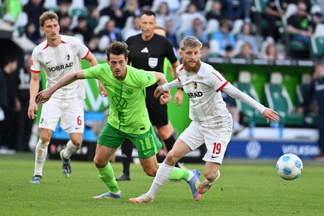 Slovenský hráč Wolfsburgu Denis Vavro (uprostred) bojuje o loptu s Janom-Niklasom Bestem (vpravo) z  Freiburgu v zápase nemeckej Bundesligy.