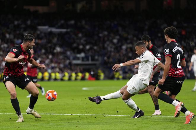 Slovenský futbalista v drese RCD Mallorca Martin Valjent (vľavo) a hráč Realu Madrid Kylian Mbappe (druhý sprava), ktorý strieľa na bránu počas zápasu 36. kola španielskej La Ligy Real Madrid - RCD Mallorca v Madride v stredu 14. mája 2025.