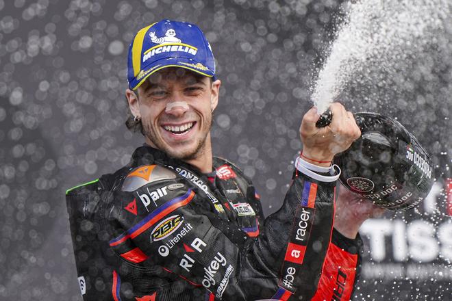 Taliansky motocyklový pretekár Marco Bezzecchi na Aprilii oslavuje na pódiu so šampanským po jeho víťazstve pretekov Veľkej ceny Veľkej Británie seriálu majstrovstiev sveta cestných motocyklov v triede MotoGP na okruhu v anglickom Silverstone.