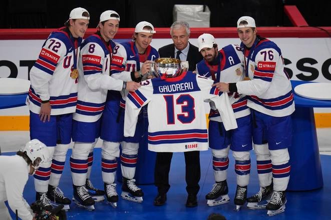 Americkí hráči držia trofej a dres zosnulého spoluhráča Johnnyho Gaudreaua po tom, ako získali titulu po ich víťazstve nad Švajčiarskom 1:0 po predĺžení zápasu vo finále Švajčiarsko - USA na MS 2025 v hokeji.