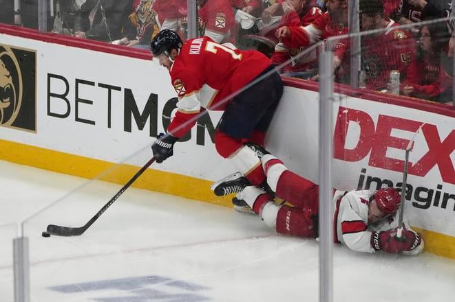 Obranca Floridy Dmitry Kulikov (7) v súboji o puk s útočníkom Caroliny Hurricanes Loganom Stankovenovom. Zo stretnutia Florida-- Carolina 0:3.