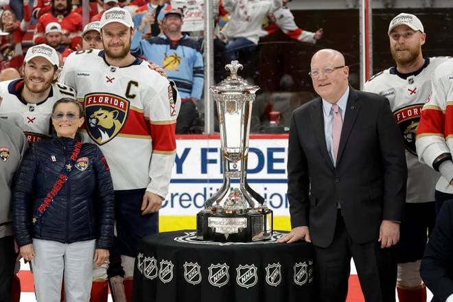 Kapitán Floridy Panthers Aleksander Barkov a zástupca komisára NHL Bill Daly pózujú s trofejou pre víťazov Východnej konferencie NHL.