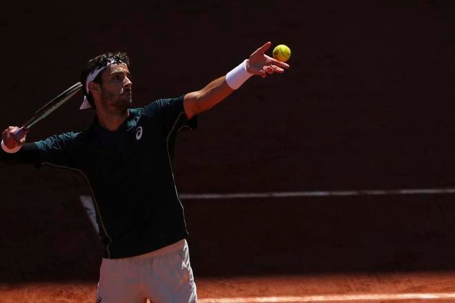 Taliansky tenista Lorenzo Musetti podáva na Argentínčana Mariana Navoneho v 3. kole mužskej dvojhry na grandslamovom turnaji Roland Garros.