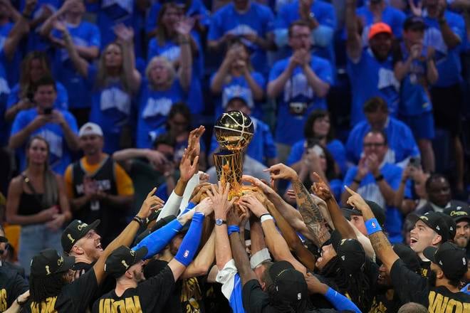 Hráči Oklahoma City Thunder držia nad hlavami trofej pre šampióna NBA.