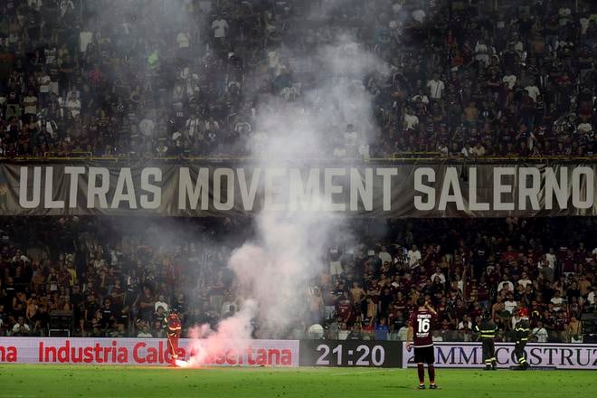 Požiarnik sa pokúša uhasiť svetlicu na ihrisku v zápase Sampdoria - Salernitana.