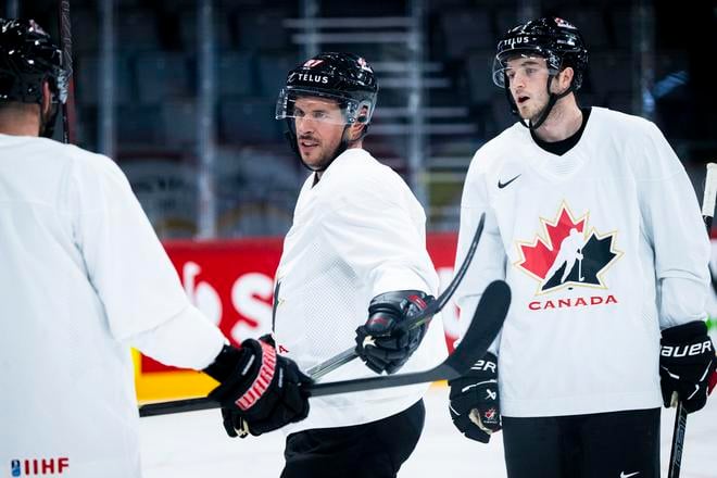 Uprostred kanadský hokejový reprezentant Sidney Crosby a vpravo spoluhráč Noah Dobson.