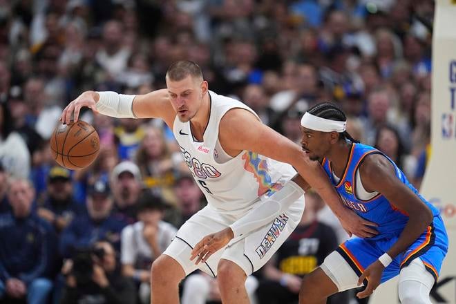 Nikola Jokic (15) v súboji o loptu s hráčom Oklahomy Shai Gilgeous-Alexandrom.
