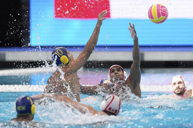 Brazílsky hráč Lucas Andrade (vľavo) sa pokúša skórovať cez Kanaďana Reuela Marka D'souzu v zápase C-skupiny Kanada - Brazília vo vodnom póle na MS v plaveckých športoch v Singapure.