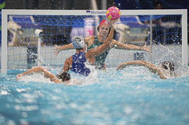 Grécka hráčka Foteini Trichová (uprostred) strieľa gól vo finále zápasu Grécko - Maďarsko vo vodnom póle na MS v plaveckých športoch v Singapure.