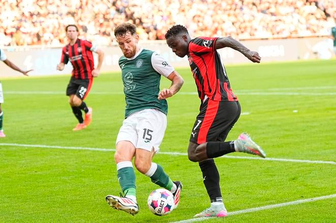 Na snímke futbalista Midtjyllandu Dju Franculino (vpravo) a hráč Hibernianu  Jack Iredal bojujú o loptu v zápase 2. predkola EL FC Midtjylland -  Hibernian v Herningu.