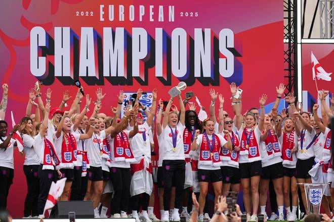 Kapitánka anglickej futbalovej reprezentácie Leah Williamsonová (uprostred) oslavuje so spoluhráčkami zisk titulu majsteriek Európy na pódiu pred Buckinghamským palácom.