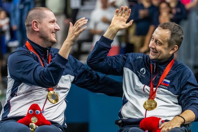 Na snímke slovenskí reprezentanti v parastolnom tenise Peter Lovaš (vľavo) a Ján Riapoš pózujú so zlatými medailami z paralympijských hier 2024.