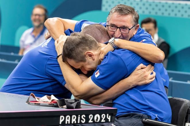 Na snímke slovenskí reprezentanti v parastolnom tenise Peter Lovaš (vľavo), Ján Riapoš (v popredí) a tréner Ján Lackovič sa tešia zo zisku zlata po finále na XVII. paralympijských hrách 2024.