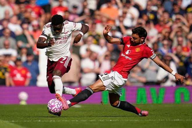 Bruno Fernandes z Manchesteru United (vpravo) súperí s Bukayom Sakom z Arsenalu počas futbalového zápasu anglickej Premier League medzi Manchesterom United a Arsenalom.