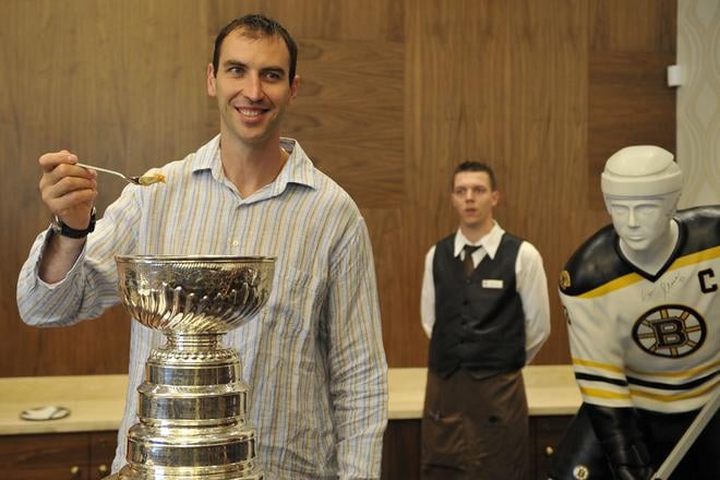 Na archívnej snímke kapitán Bostonu Bruins Zdeno Chára si pochutnáva na obľúbenom ryžovom nákype z legendárnej trofeje v roku 2011.