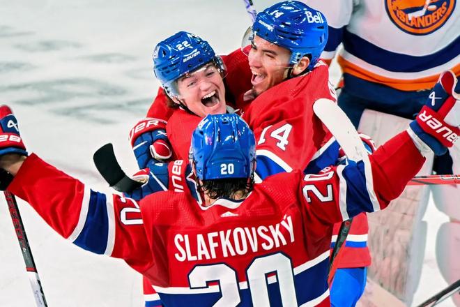 Juraj Slafkovský a jeho spoluhráči z prvého útoku Montrealu Canadiens Cole Caufield (vľavo) a Nick Suzuki v emócii po strelení gólu.