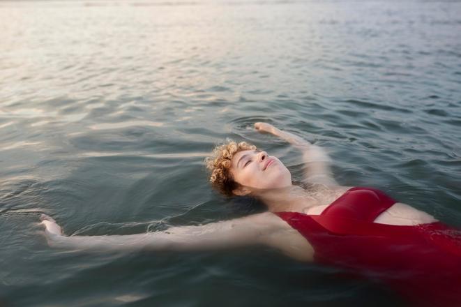 Woman smiling and floating in water.