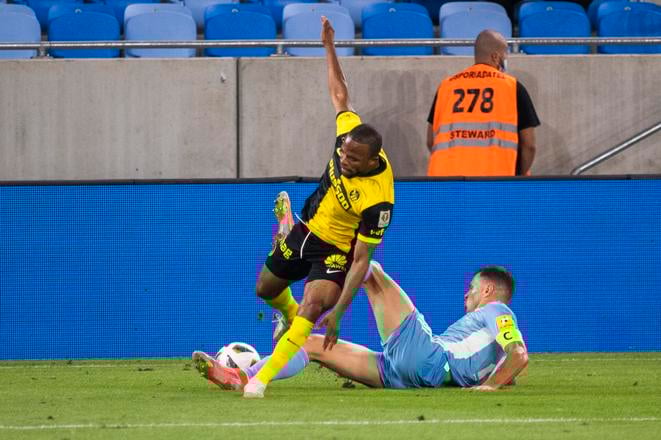 Vasil Božikov (na zemi) v súboji s Meschackom Eliom z Young Boys Bern počas 1. zápasu 2. predkola Ligy majstrov 2021/22 na Tehelnom poli.