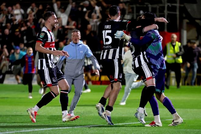 Hráči Grimsby Town's bežia k brankárovi Christymu Pymovi po úspešnom pokutovom rozstrele proti Manchestru United v Ligovom pohári.