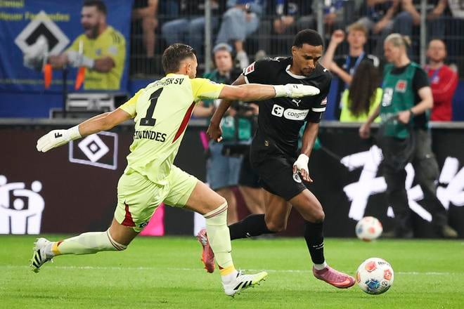 Andreas Hountondji z FC St. Pauli (vpravo) prekonáva brankára Hamburger SV Daniela Heuera Fernandesa.