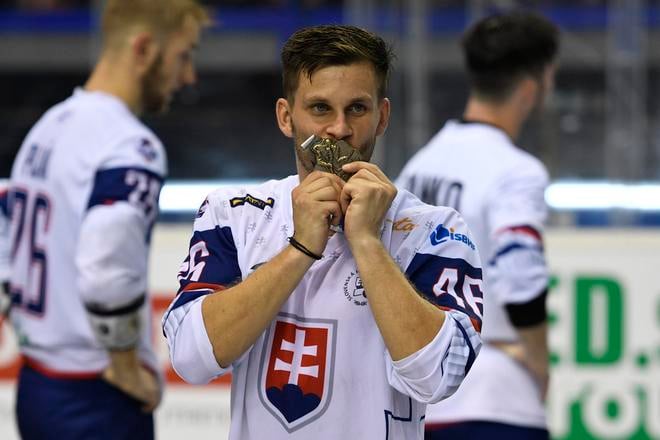 Jaroslav Martinusík v reprezentačnom drese bozkáva zlatú medailu na MS v hokejbale v roku 2019.