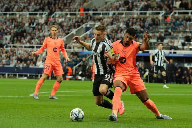 Hráč Newcastle Harvey Barnes(vľavo) bojuje o loptu s Ronaldom Araujom z Barcelony (vpravo) počas zápasu 1. kola ligovej fázy Ligy majstrov Newcastle United - FC Barcelona.