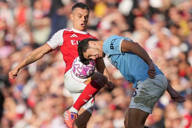 Futbalista Manchestru City Abdukodir Chusanov (vpravo) a hráč Arsenalu Leandro Trossard bojujú o loptu v zápase 5. kola anglickej Premier League Arsenal Londýn - Manchester City.