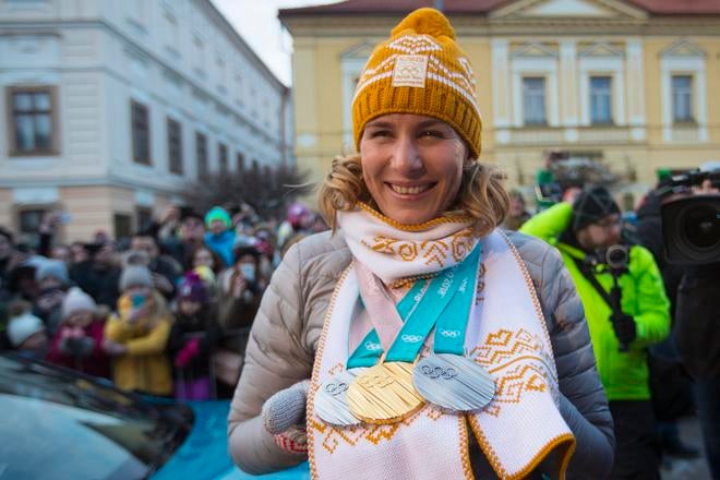 Slovenská biatlonistka Anastasia Kuzminová pózuje s medailami po príchode na oslavu svojich úspechov na ZOH v kórejskom Pjongčangu s fanúšikmi na Námestí SNP v Banskej Bystrici 1. marca 2018. 