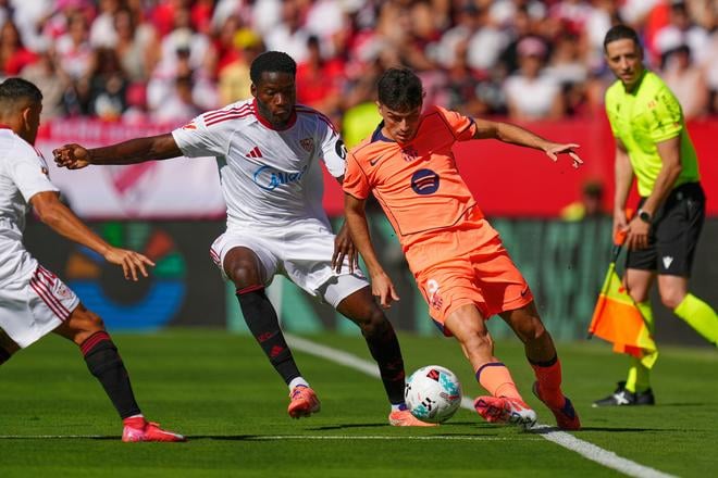 Hráč FC Barcelony Pedri (uprostred vpravo) a hráč tímu FC Sevilla Lucien Agoume bojujú o loptu v zápase 8. kola španielskej La Ligy FC Sevilla - FC Barcelona.