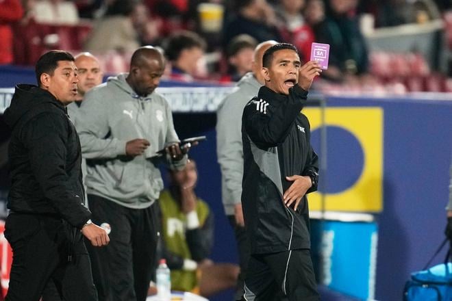Asistent rozhodcu ukazuje na základe trénerskej výzvy kartu na MS do 20 rokov vo futbale.