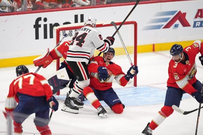 Hráč Floridy Panthers Evan Rodrigues (17) v ostrom súboji pred Samom Laffertym (24) pred bránkou Sergeja Bobrovského. Zo stretnutia NHL Florida - Chicago.
