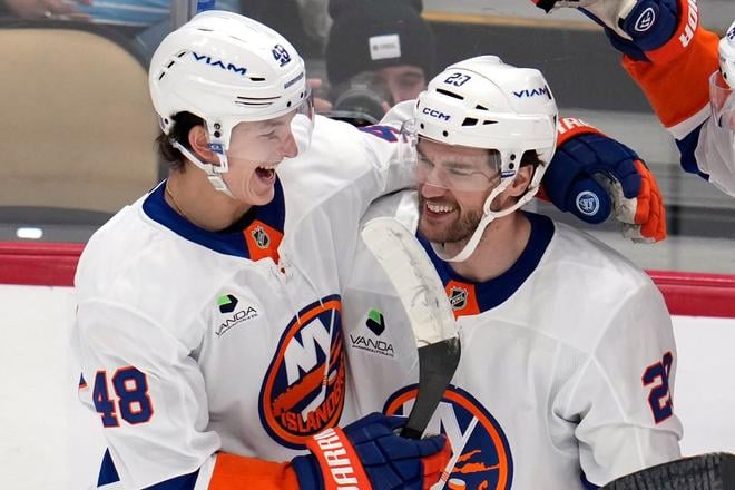 Hráč New Yorku Islanders Jonathan Drouin (vpravo) sa teší z gólu so spoluhráčom Matthewom Schaeferom (vľavo) počas zápasu zámorskej NHL proti Pittsburghu Penguins.