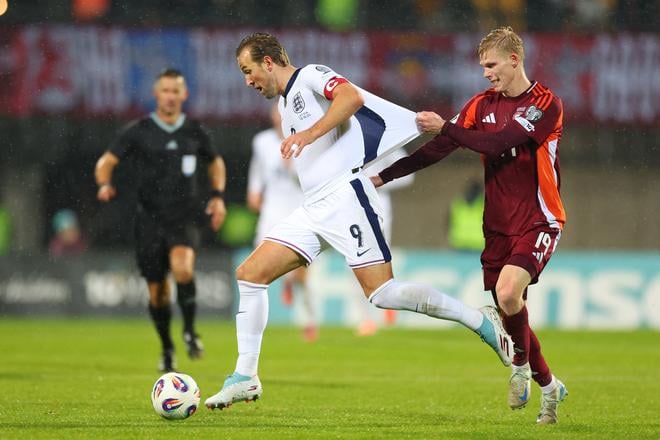 Lotyš Maksims Tonisevs (vpravo) sa márne snaží zastaviť Harryho Kanea v zápase kvalifikácie MS 2026.