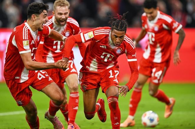Futbalista Bayernu Mníchov Michael Olise (uprostred) sa teší z gólu počas zápasu 7. kola nemeckej Bundesligy Bayern Mníchov - Borussia Dortmund.
