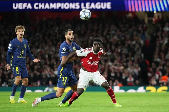 Slovenský futbalista v drese Atletica Madrid Dávid Hancko (uprostred) a hráč Arsenalu Bukayo Saka (vpravo).
