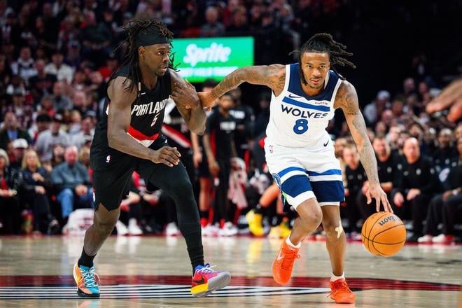 Bones Hylan z tímu Minnesota Timberwolves uniká Jrue Holidayovi z Portlandu.