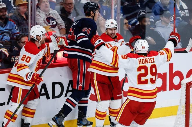 Blake Coleman (20), Mikael Backlund (11) and Samuel Honzek (29) sa tešia z gólu.